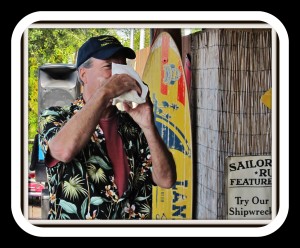Bob sounding conch shell at Pine Island Reader Rendezvous
